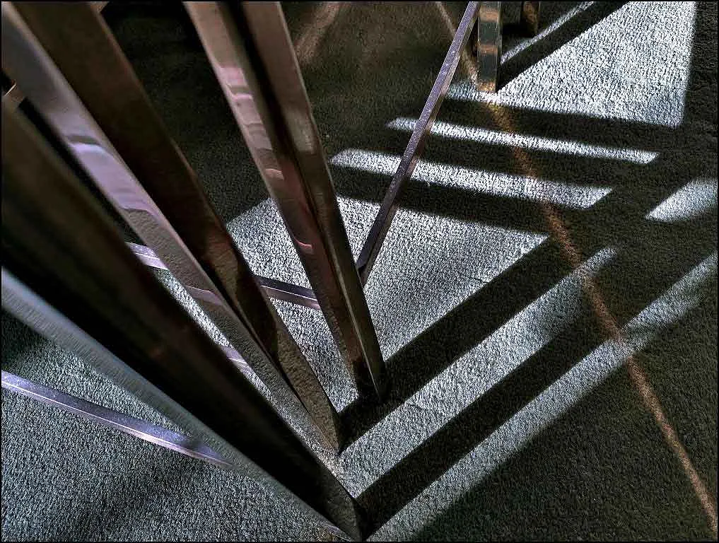 shadows from a coffee table on a grey carpet
